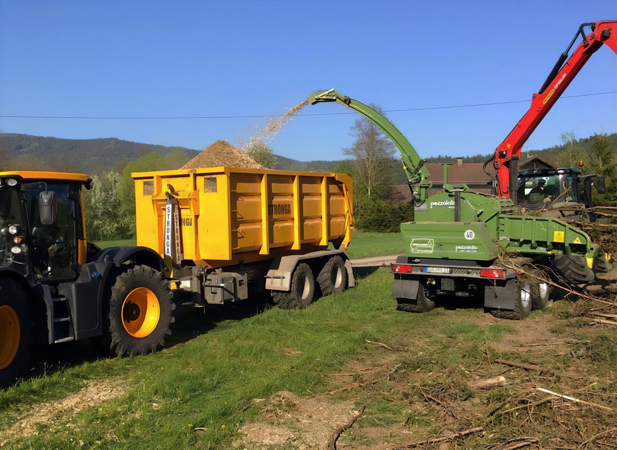 Pezzolato wood chipper chipping green wood into a Stronga hook lift trailer, ready for drying in the FlowDrya